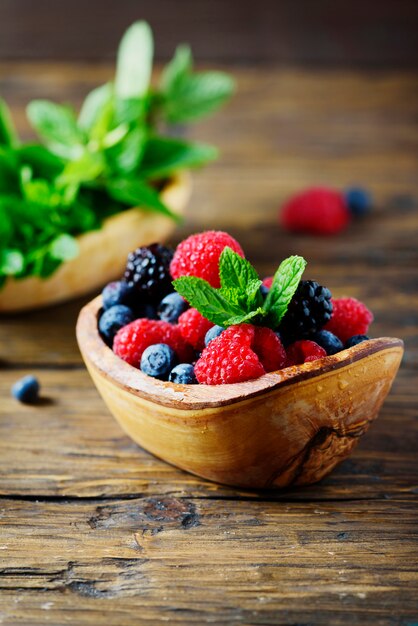 Mischung aus Sommerbeeren und Minze auf dem Holztisch