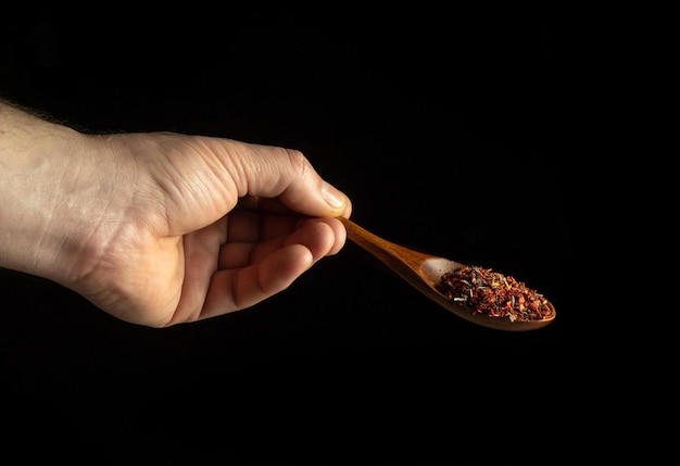 Mischung aus trockenen Gewürzen in einem Holzlöffel in der Kochhand, bevor sie zum Essen hinzugefügt wird