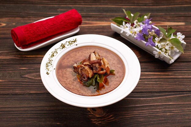 Miso-Suppe mit Shiitake-Pilzen auf Holzhintergrund