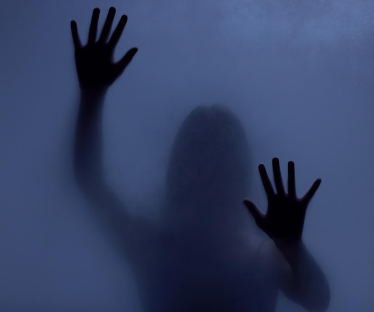 Foto mistério de horror e sombra de uma mulher em uma janela por medo de fuga ou pesadelo mãos escuras e uma garota fantasma ou pessoa com atividade paranormal, comportamento assustador ou movimento estranho em um estúdio