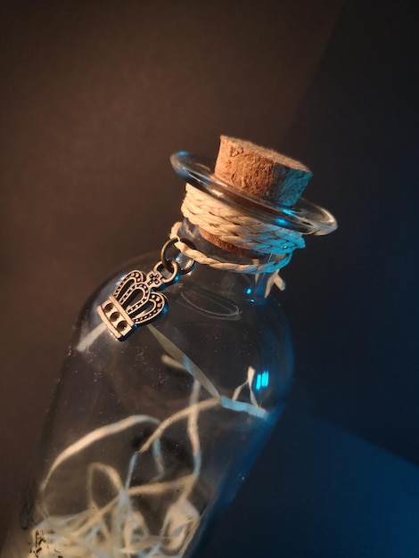 Una misteriosa botella de vidrio con el emblema real frente al fondo oscuro