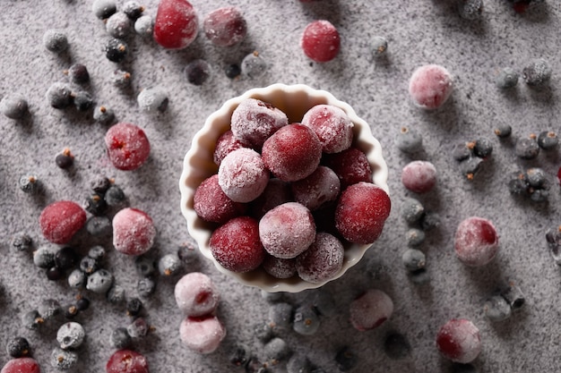 Mistura congelada de frutas vermelhas de cereja azeda e groselha preta em plano de fundo cinza, vista de cima