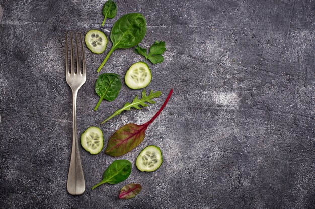 Mistura cortada do pepino e da salada. Fundo verde dos vegetais, conceito saudável do alimento. Vista do topo