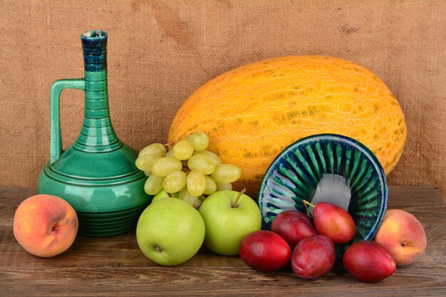 Mistura de frutas de verão e jarro de cerâmica velho com vinho