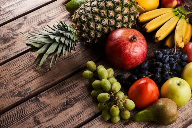 Mistura de frutas tropicais exóticas coloridas e suculentas frescas na vista superior do plano de fundo de madeira