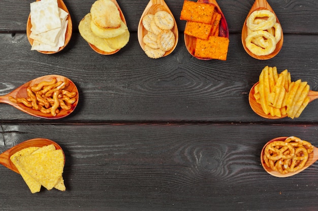 Mistura de lanches: biscoitos, biscoitos, salgadinhos e nachos em cima da mesa