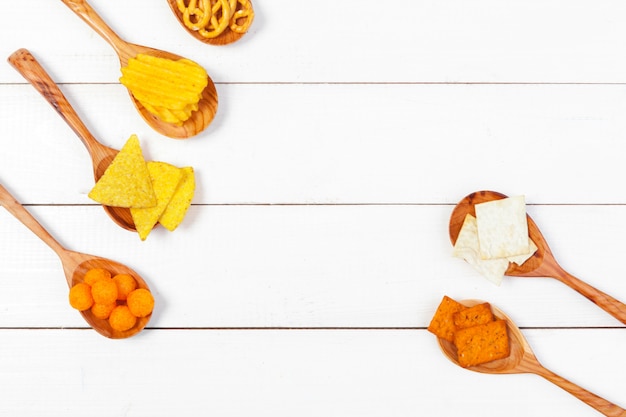 Mistura de lanches: biscoitos, biscoitos, salgadinhos e nachos em cima da mesa