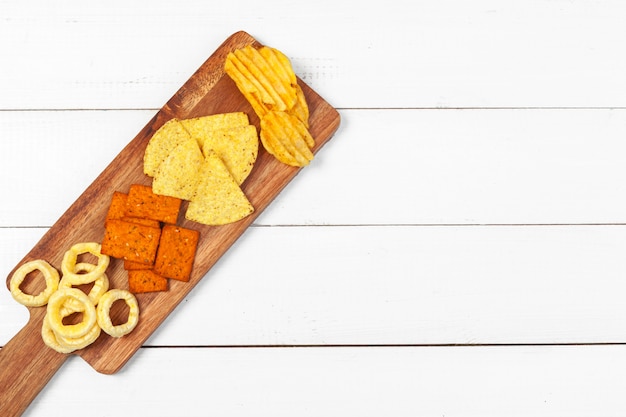 Mistura de lanches: biscoitos, biscoitos, salgadinhos e nachos em cima da mesa