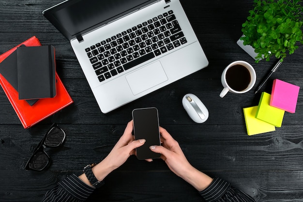 Mistura de material de escritório e gadgets em uma mesa de madeira vista de fundo