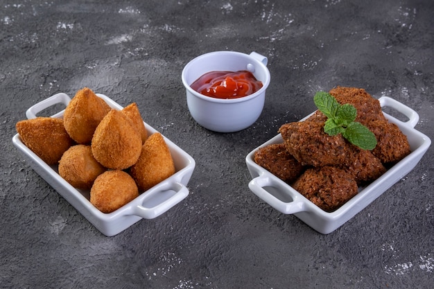 Mistura de petisco salgado frito com coxinha e quibe frito.