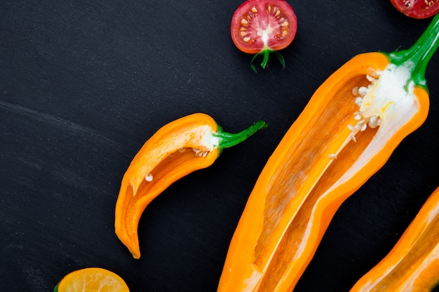 Misturado de meia pimenta vermelha e amarela com um ramo verde perto de tomate cereja