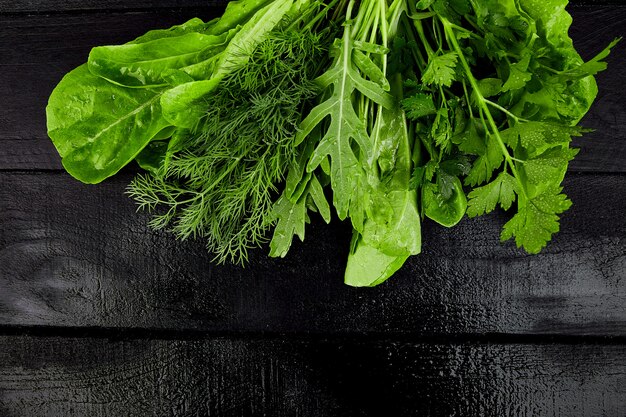 Misture a salada de folhas na mesa preta.