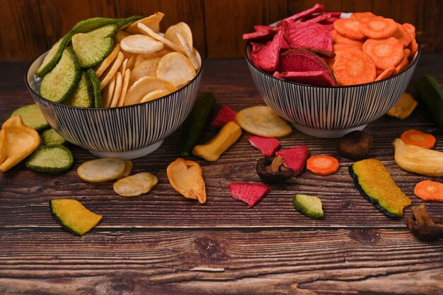 Foto misture chips vegetais na mesa de madeira. comida vegana.