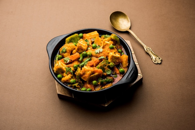 Misture curry de vegetais - a receita do prato principal indiano contém cenouras, couve-flor, ervilhas e feijão, milho bebê, pimentão e paneer ou queijo cottage com masala tradicional e curry