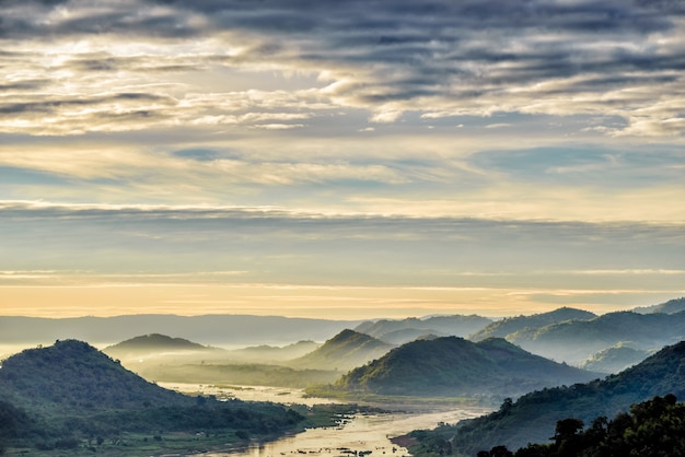 Foto misty montañas y ríos al amanecer.