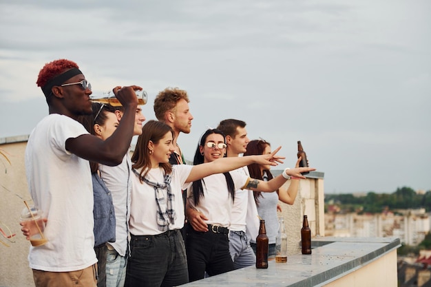 Mit Alkohol hoch stehen Bewölkter Himmel Eine Gruppe junger Leute in Freizeitkleidung feiern tagsüber gemeinsam auf dem Dach