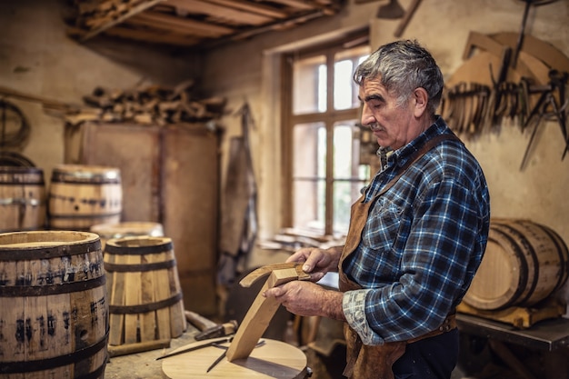 Mit altmodischer Methode, um handgefertigte Holzfässer für Spirituosen zu bauen.