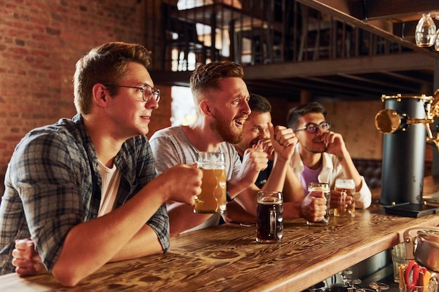 Mit Bier in den Händen Menschen in Freizeitkleidung sitzen in der Kneipe