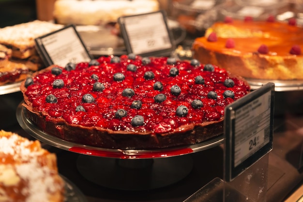 Mit Blaubeeren dekorierter Kirschkuchen in einem Schaufenster