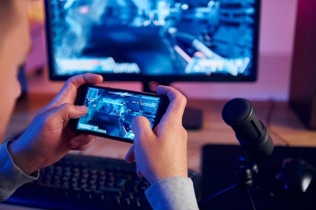 Mit dem Smartphone Online-Streamer, der zu Hause ein FPS-Shooter-Spiel spielt