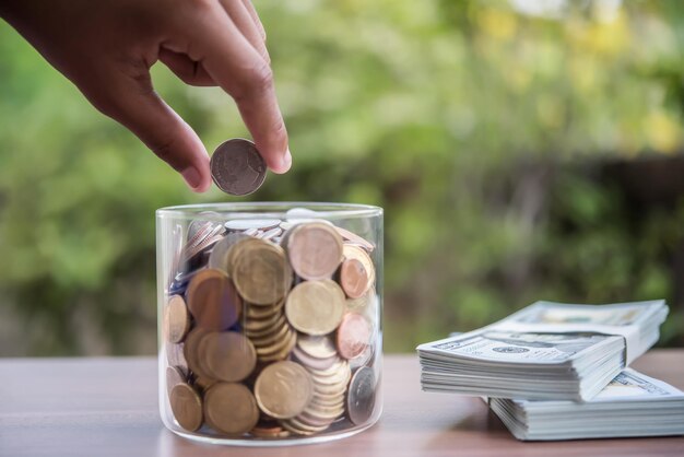 Mit der Hand Münzen in ein Glas mit Geld stapeln Schritt Wachstum Wachstum Geld sparen
