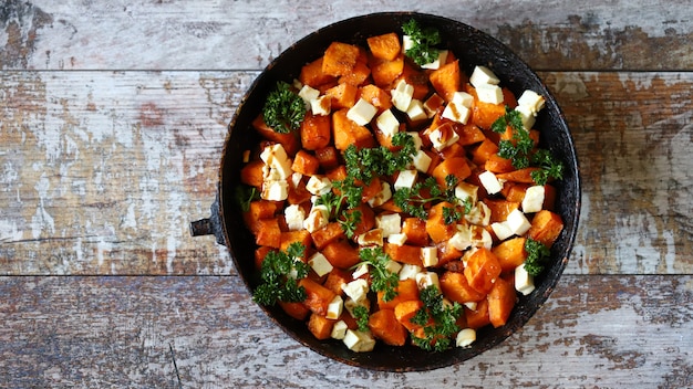 Mit Feta-Käse gebackene Kürbisstücke in einer Pfanne