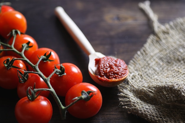 Mit frischen Kirschtomaten verzweigen. Reife rote Tomaten. Tomaten und Nudeln mit Gewürzen