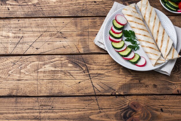 Mit Käse und Kräutern rollen. Gegrilltes Fladenbrot mit Füllung. Gurkenrettichsalat. Das Konzept eines gesunden Frühstücks. Speicherplatz kopieren