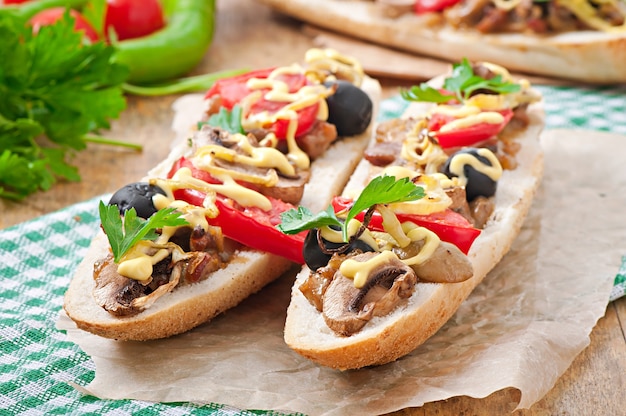 Mit Kalbfleisch und Pilzen gefülltes Baguette mit Tomaten und Käse