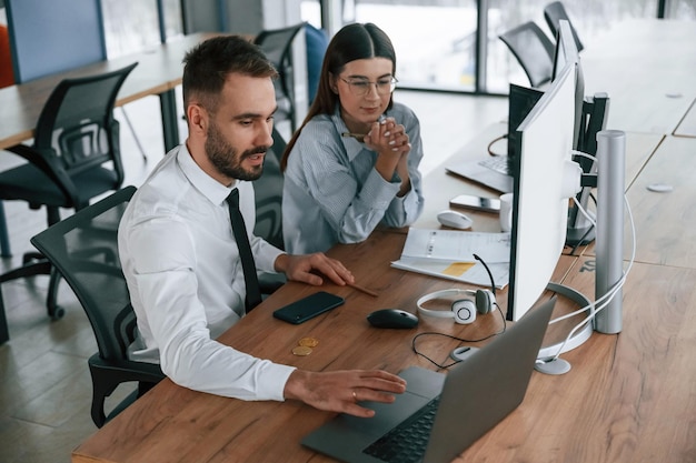 Mit Laptop zwei Angestellte arbeiten zusammen im Büro