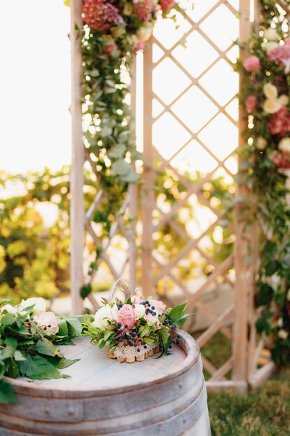Mit Rosen verziertes Holzfass steht neben einer faltbaren Hochzeitswand