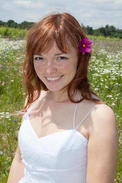 Mit roten Haaren auf der Blumenwiese spazieren