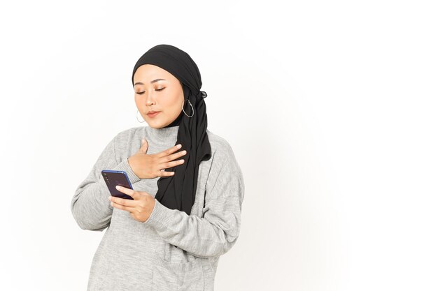 Mit Smartphone der schönen asiatischen Frau mit Hijab isoliert auf weißem Hintergrund