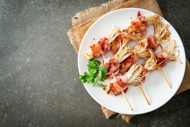 Mit Speck umwickelte Pilzspieße mit goldener Nadel