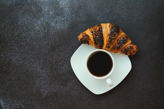 mit tassen heißem schwarzen kaffee und süßem croissant auf blauem hintergrund. Ansicht von oben, kopieren. Lebensmittel