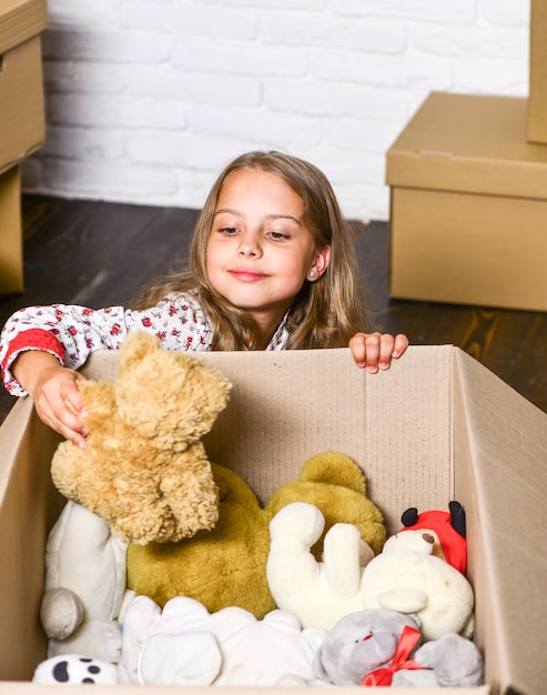 Mit Zuversicht nach Hause kommen Kauf einer neuen Wohnung Kartons Umzug in ein neues Haus Reparatur eines Zimmers neue Wohnung glückliches kleines Mädchen mit Spielzeug glückliches Kind Karton