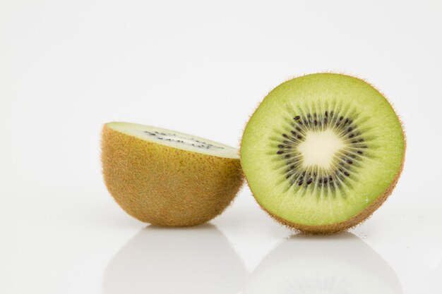 La mitad aislada cortó la fruta de kiwi en blanco.