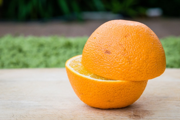 La mitad de corte de textura de naranja en la mesa de madera.