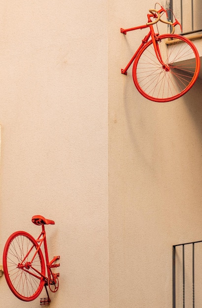 La mitad delantera y trasera separadas de una bicicleta roja vintage fijada a la pared de un bloque de construcción