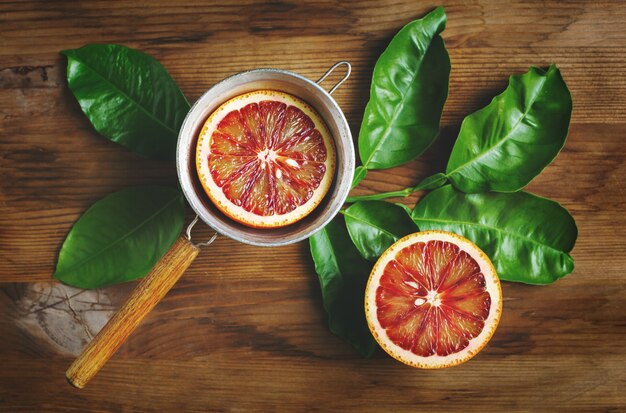 La mitad de la fruta de naranja sanguina se cierra sobre la mesa de madera. Vista superior.