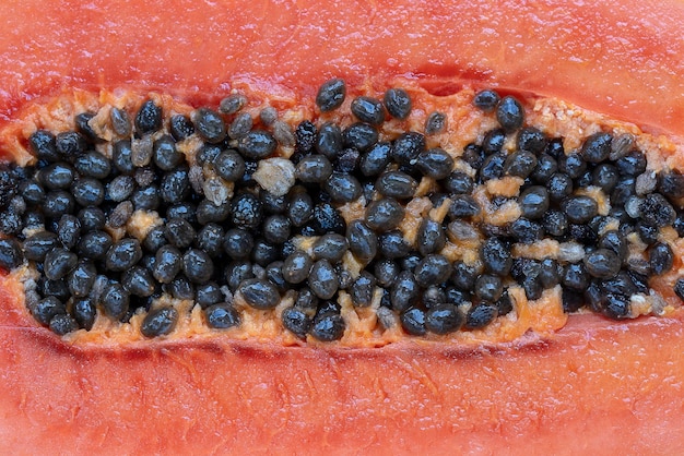 La mitad de la fruta de papaya dulce madura con primer plano de fondo de semillas