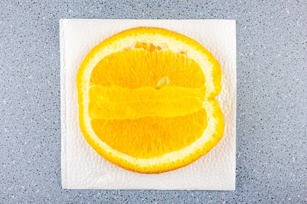 La mitad de una naranja cortada en una servilleta blanca sobre la mesa Jugosa naranja brillante natural en el corte