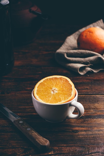 La mitad de naranja en una taza blanca