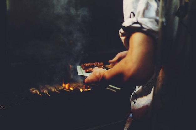 La mitad del torso de hombre preparando comida en la cocina