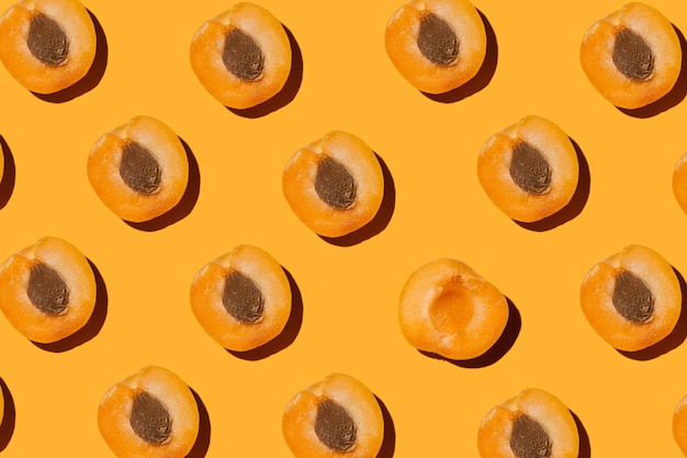 Foto mitades de albaricoques con piedras sobre un fondo naranja