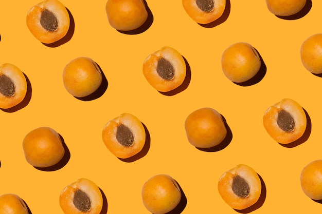 Mitades de albaricoques con piedras sobre un fondo naranja
