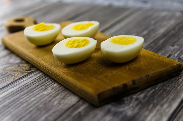 Mitades de huevo cocido sobre tabla de cortar de madera
