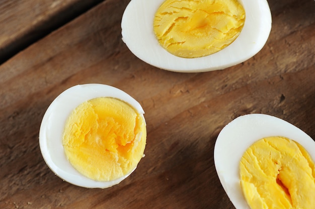 Mitades de huevos cocidos sobre una mesa rústica de madera