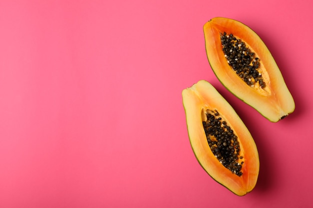 Mitades de papaya madura sobre fondo rosa