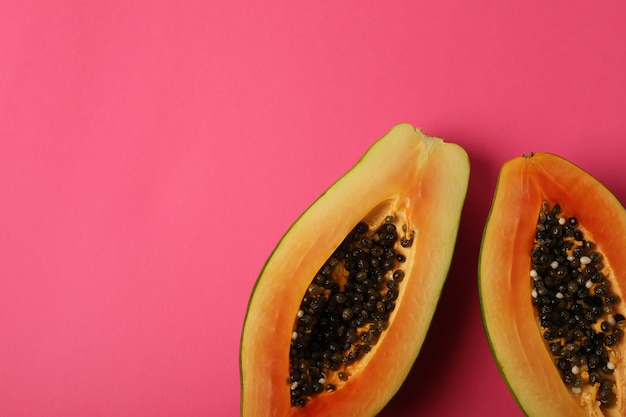 Mitades de papaya madura sobre fondo rosa